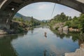 A man swings from a rope into the Rogue River