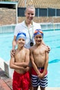 Swimming instructor with boys at poolside Royalty Free Stock Photo