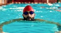 Swimming - male swimmer swimming breaststroke. Close up portrait of man doing breast stroke swimming in pool wearing red