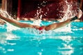 Swimming - male swimmer swimming breaststroke. Close up portrait of man doing breast stroke swimming in pool wearing red