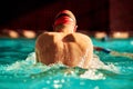 Swimming - male swimmer swimming breaststroke shot from the back. Close-up of the back of a man swimming breaststroke in