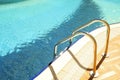 Swimming pool area of new luxury residential complex with tiles, chrome stairs handles and drains. Sunny beautiful day. Royalty Free Stock Photo