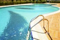 Swimming pool area of new luxury residential complex with tiles, chrome stairs handles and drains. Sunny beautiful day. Royalty Free Stock Photo