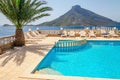 Swimming pool area and sunbeds under palm tree Royalty Free Stock Photo