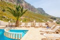 Swimming pool area and sunbeds under palm tree Royalty Free Stock Photo