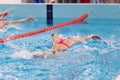 Swimming pool athlete training indoors for professional competition. Female swimmer performing the butterfly stroke at Royalty Free Stock Photo