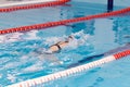 Swimming pool athlete training indoors for professional competition. Female swimmer performing the butterfly stroke at Royalty Free Stock Photo