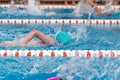 Swimming pool athlete training indoors for professional competition. Teenager swimmer doing free style Royalty Free Stock Photo