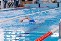 Swimming pool athlete training indoors for professional competition. Teenager swimmer doing free style Royalty Free Stock Photo