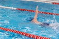 Swimming pool athlete training indoors for professional competition. Teenager swimmer doing free style Royalty Free Stock Photo