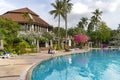 Swimming pool among a beautiful garden with tall palm trees on the territory of Duangjitt Resort and Spa in Phuket Royalty Free Stock Photo