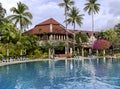 Swimming pool among a beautiful garden with tall palm trees on the territory of Duangjitt Resort and Spa in Phuket Royalty Free Stock Photo