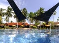 Swimming pool among a beautiful garden with tall palm trees on the territory of Pelangi Beach Resort Spa hotel Royalty Free Stock Photo