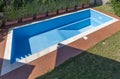 A swimming pool with blue coating in a private garden is completely empty, waiting to be filled with water Royalty Free Stock Photo