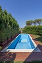 A swimming pool with blue coating in a private garden is completely empty, waiting to be filled with water Royalty Free Stock Photo