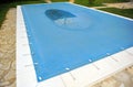 Swimming pool with a blue tarp for protection in winter Royalty Free Stock Photo