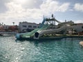 A swimming pool with blue warm water with large high cheerful extreme water slides for fun in an open-air water park, aquapark on Royalty Free Stock Photo