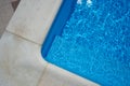 Swimming pool with blue water outdoors with stone gray edge, closeup. Top view Royalty Free Stock Photo