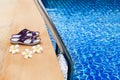 Swimming pool, blue water, white plumeria frangipani flowers, women flip flops, poolside, tropical sea beach, summer holidays Royalty Free Stock Photo