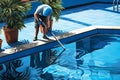 Swimming pool cleaning. Man janitor is cleaning the pool. Service care.