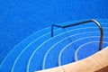 Swimming pool with a clear blue water and steel ladder in the resort. Royalty Free Stock Photo