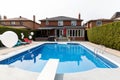 Swimming pool with clear blue water and sun loungers in a cozy place Royalty Free Stock Photo