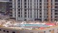 Swimming pool construction site with on the rooftop of parking with many workers aerial timelapse. Royalty Free Stock Photo