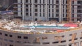 Swimming pool construction site with on the rooftop of parking with many workers aerial timelapse. Royalty Free Stock Photo