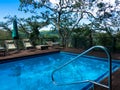 Swimming pool with deck chairs looking over the african wilderness in a luxury safari lodge. Relaxing vacation concept. Royalty Free Stock Photo