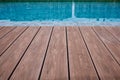 Swimming pool deck wood floor and blue water background. Royalty Free Stock Photo