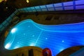 Swimming pool with different colored lights at night from above
