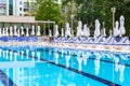 Swimming pool with empty loungers and closed umbrellas at luxury hotel Royalty Free Stock Photo