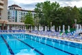 Swimming pool with empty loungers and closed umbrellas at luxury hotel Royalty Free Stock Photo