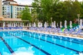 Swimming pool with empty loungers and closed umbrellas at luxury hotel Royalty Free Stock Photo