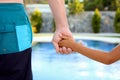 Swimming pool. Father holds the hand of a small child on a blue background