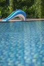 Swimming pool in a hotel with a dolphin slider on the pool side.