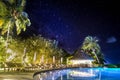 Swimming pool at night with palm trees and Milky Way sky view. Summer vacation, abstract relax background Royalty Free Stock Photo