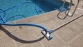 Swimming pool maintenance with vacuum hose and cleaning equipment on poolside Royalty Free Stock Photo