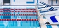 Swimming pool with marked red and white lanes. Empty swimming pool without people with quiet standing water.