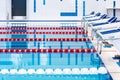 Swimming pool with marked red and white lanes. Empty swimming pool without people with quiet standing water.