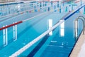 Swimming pool with marked red and white lanes. Empty swimming pool without people with quiet standing water.