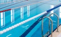 Swimming pool with marked red and white lanes. Empty swimming pool without people with quiet standing water.