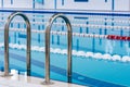 Swimming pool with marked red and white lanes. Empty swimming pool without people with quiet standing water.