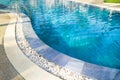 Swimming pool with metal ladder.Fragment of kidney-shaped swimming pool with stair. Cleaning blue color water