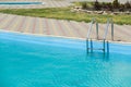 Swimming pool with metal stairs outdoor in a private house. Royalty Free Stock Photo