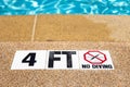 Swimming pool with no diving warning sign and 4 foot depth marker Royalty Free Stock Photo