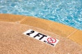 Swimming pool with NO Diving warning sign and 2 ft depth marker Royalty Free Stock Photo