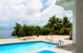 Swimming pool by the ocean with lounge chairs and chiminea Royalty Free Stock Photo