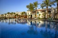 Swimming pool with the some beach lounges with a view on green palms