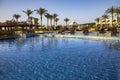 Swimming pool with the some beach lounges with a view on green palms